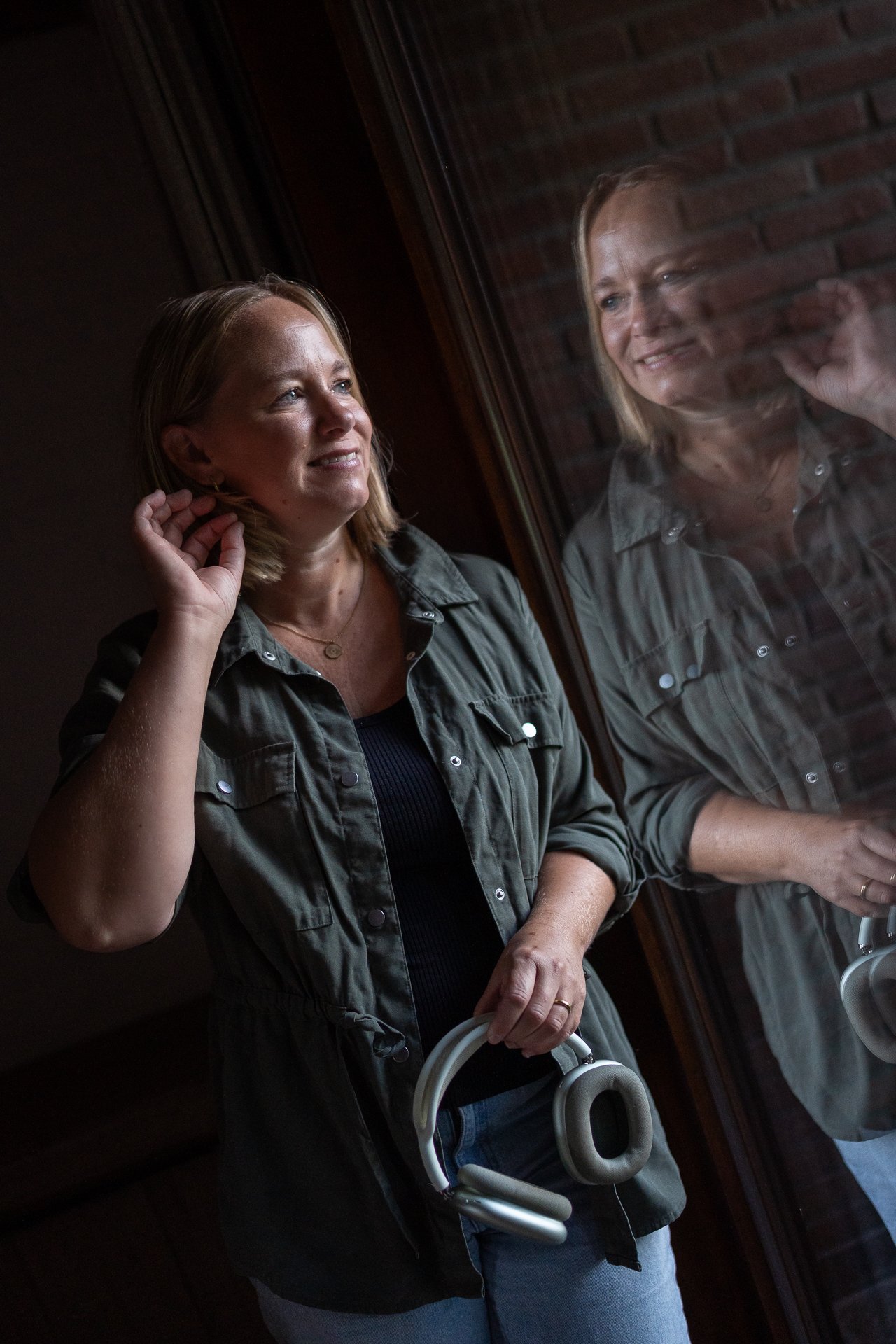 Marjolein met koptelefoon bij het raam